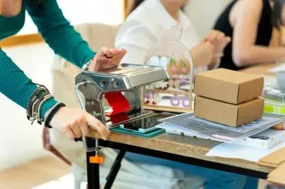 Manual packaging machine used to seal product trays on a workbench
